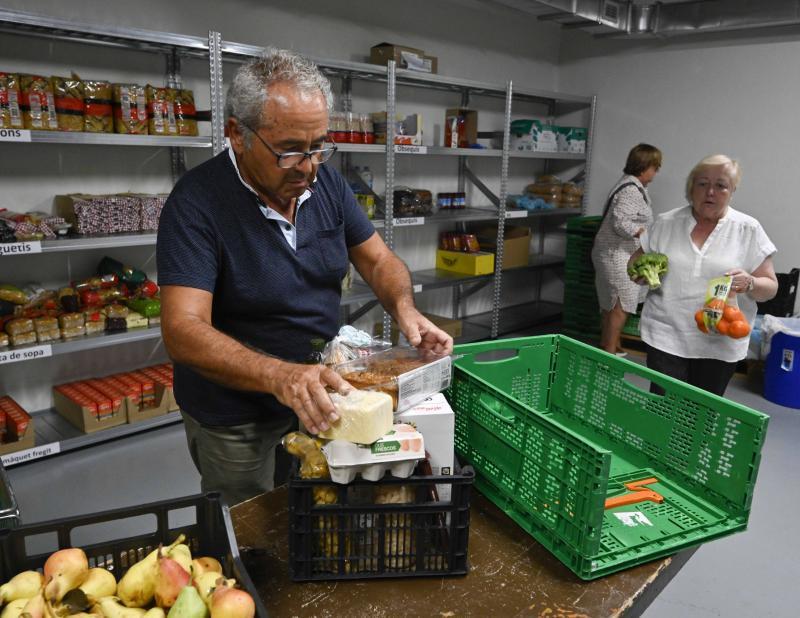 Un voluntario prepara una cesta de alimentos.