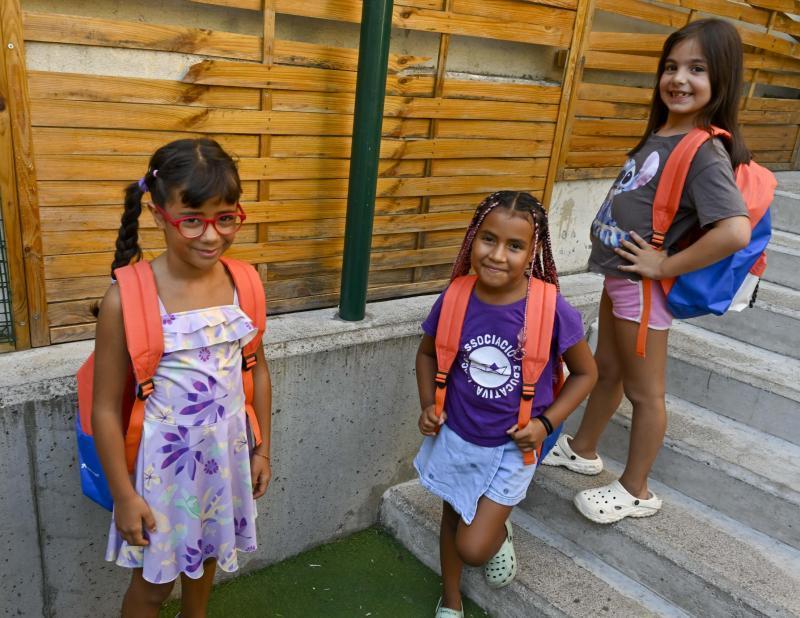 Tres nenes que participen al programa CaixaProinfància amb les seves motxilles noves.